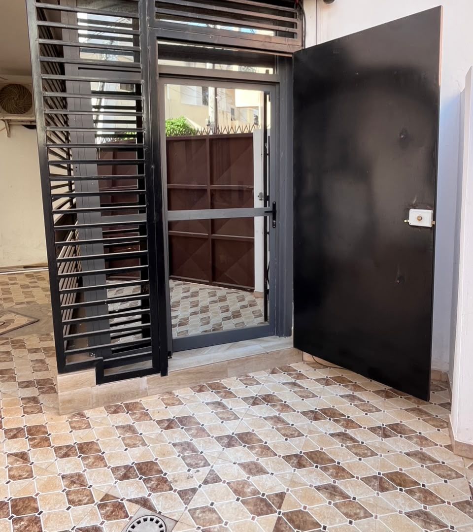 L'entrée du bureau : grille noire et porte vitrée, Villa n° 20, Cité Sonatel 2